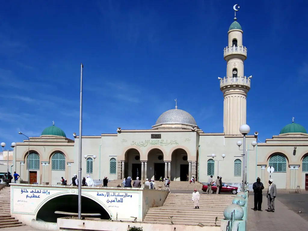 The Great Mosque of Asmara, a pale stone front with a tall minaret, in bright sun