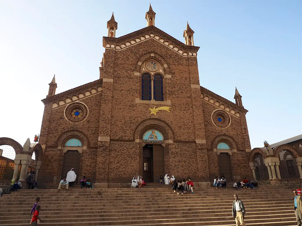 St Joseph's Catholic Cathedral in Asmara, red brick with a tall Lombard bell tower, seen down the avenue