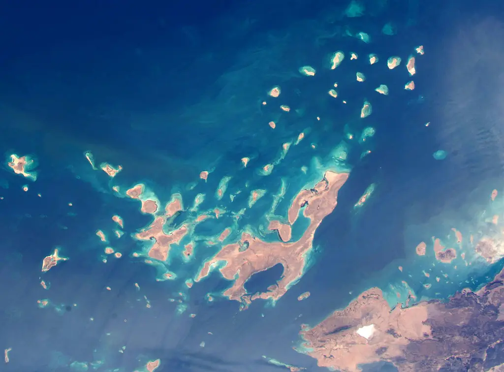 The Dahlak islands seen from orbit, dozens of sandy islands ringed with pale turquoise reef in dark blue sea