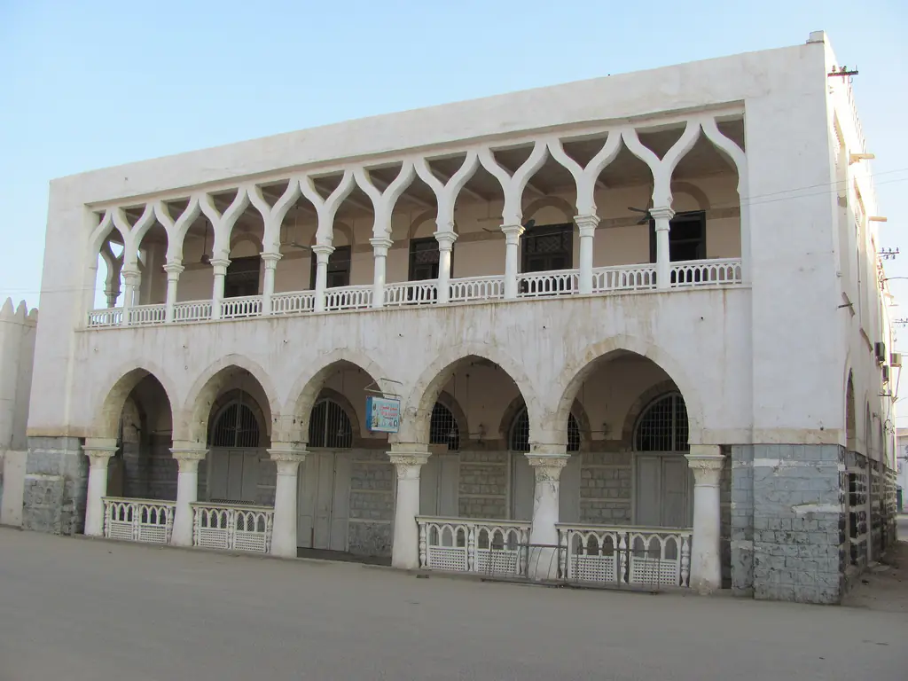 A whitewashed two-storey house in Massawa's old town with a row of pointed arches along its upper balcony