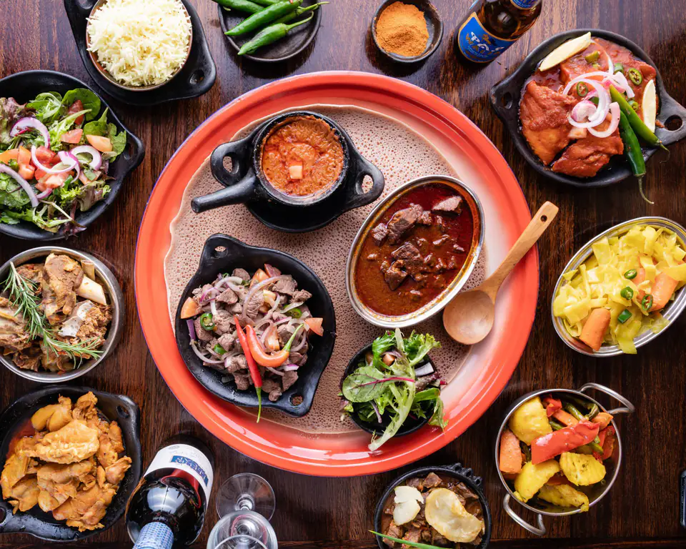 A table of dishes on injera, with rice and salad